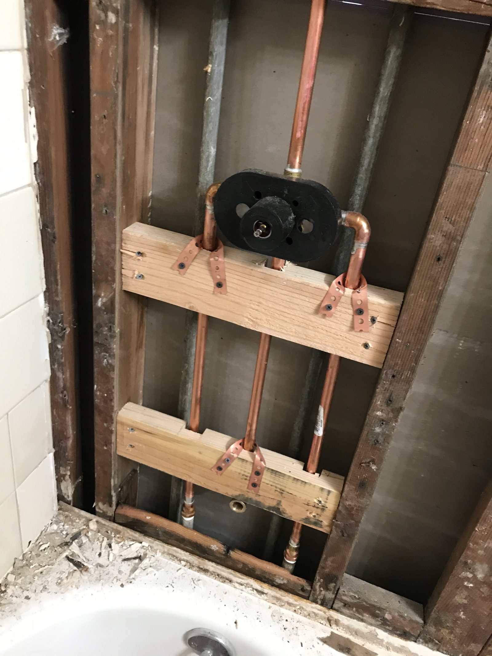 Bathroom Rough-In — Shower valve and copper supply lines installed during a bathroom remodel — preparing the wall cavity for new tile and finish.