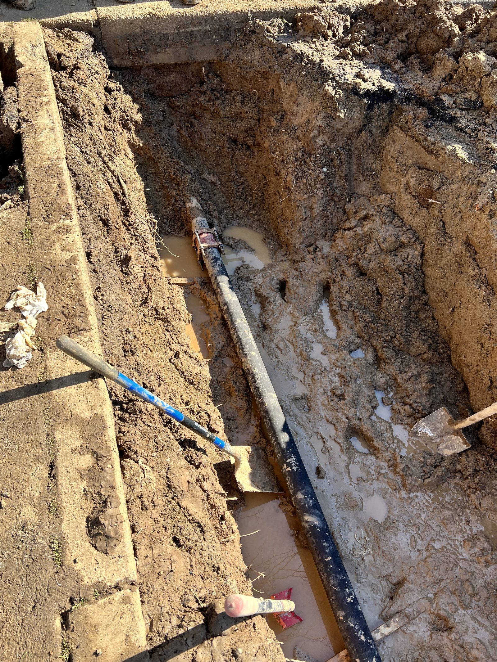 Sewer Line Replacement — Replacing a failed sewer line in a deep trench. Old line removed and new pipe set to proper grade.