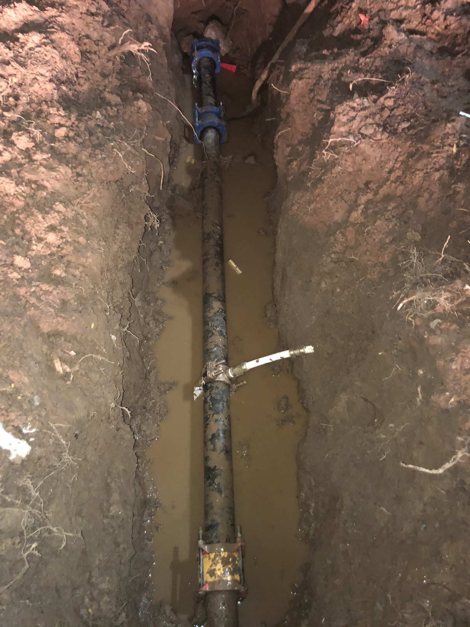 Main Water Line Replacement — New water service line installed in trench, ready for inspection and backfill.